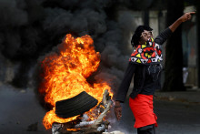 Demonštrantka pri horiacej barikáde počas „národného štrajku“ proti výsledku volieb v meste Luis Cabral v Mapute v Mozambiku. FOTO: Reuters