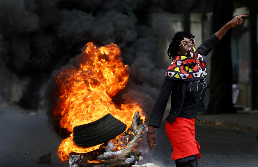 Demonštrantka pri horiacej barikáde počas „národného štrajku“ proti výsledku volieb v meste Luis Cabral v Mapute v Mozambiku. FOTO: Reuters