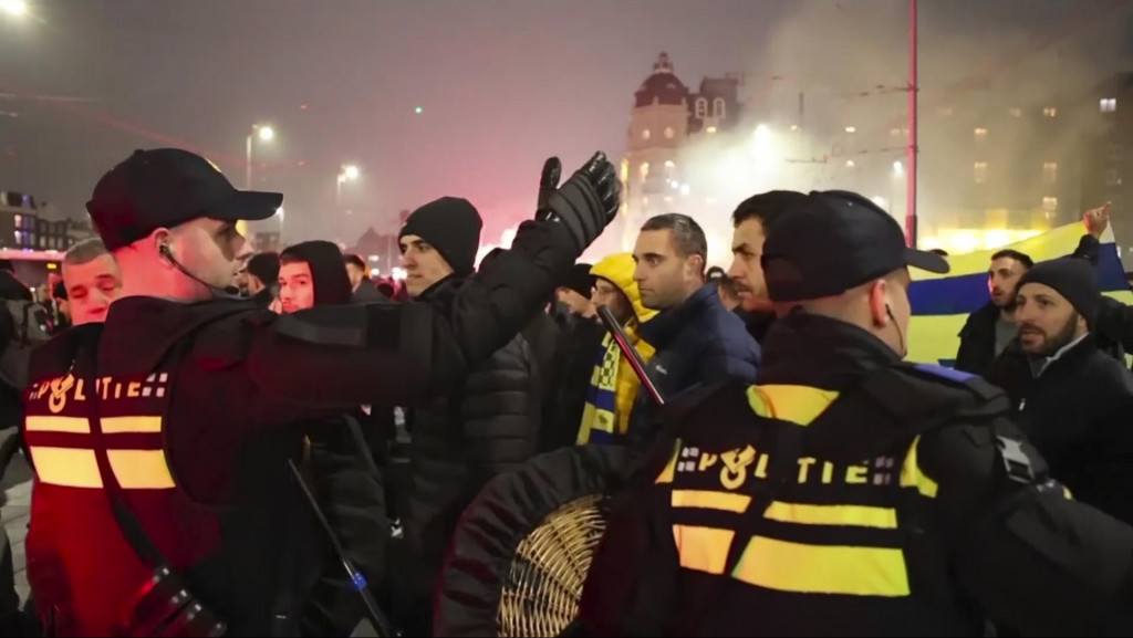 Policajti eskortujú futbalových fanúšikov Maccabi Tel Avivu na stanicu metra, ktoré ich dopraví na futbalový štadión Ajaxu po pochode propalestínskych demonštrantov v Amsterdame. FOTO: TASR/AP