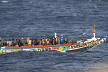 Migranti sa tlačia na drevenom člne, keď sa plavia do prístavu v La Restinge na kanárskom ostrove El Hierro. FOTO: TASR/AP