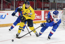 Hokejista Slovenska Juraj Pekarčík a hráč Švédska Theo Lindstein bojujú o puk počas zápasu základnej B-skupiny Slovensko - Švédsko na MS hráčov do 20 rokov v kanadskom meste Ottawa. FOTO: TASR/AP