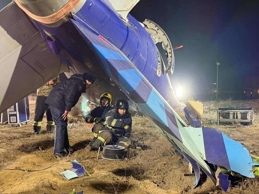 Záchranári kľačia pri vraku lietadla Embraer 190 azerbajdžanských aerolínií AZAL, ktoré sa zrútilo pri meste Aktau na západe Kazachstanu vo štvrtok 26. decembra 2024. FOTO: TASR/AP