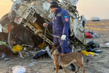 Záchranár so psom prehľadáva vrak lietadla Embraer 190 azerbajdžanských aerolínií AZAL, ktoré sa zrútilo pri meste Aktau na západe Kazachstanu vo štvrtok 26. decembra 2024.FOTO: TASR/AP