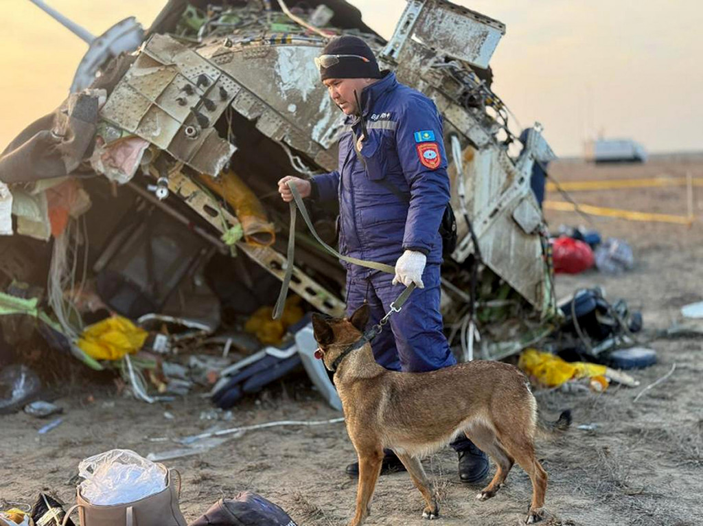 Záchranár so psom prehľadáva vrak lietadla Embraer 190 azerbajdžanských aerolínií AZAL, ktoré sa zrútilo pri meste Aktau na západe Kazachstanu vo štvrtok 26. decembra 2024.FOTO: TASR/AP