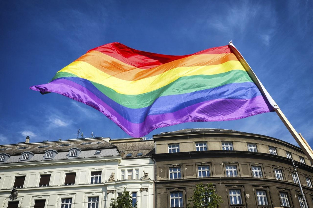 Vlajka LGBTQ+ komunity za budovou mesta. FOTO: Pixabay