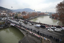 Demonštranti sa radia do reťaze počas protivládneho zhromaždenia v gruzínskom Tbilisi. FOTO: TASR/AP