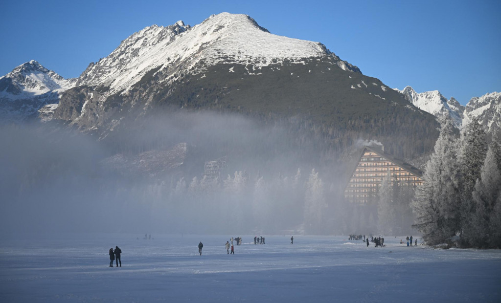 Na snímke turisti sa prechádzajú po zamrznutom Štrbskom plese vo Vysokých Tatrách. FOTO: TASR/František Iván