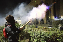 Demonštranti odpaľujú petardy do parlamentu počas protestu proti rozhodnutiu vlády pozastaviť rokovania o vstupe do Európskej únie v gruzínskom meste Tbilisi. FOTO: TASR/AP