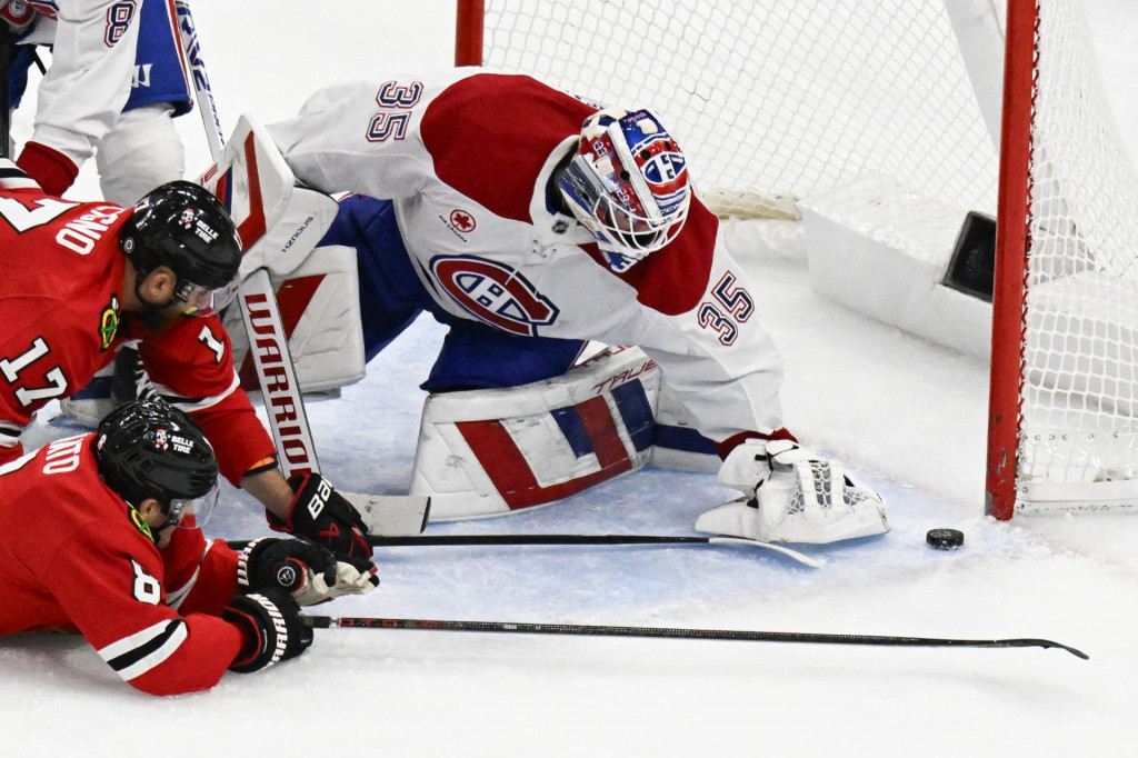 Center Chicaga Blackhawks Ryan Donato (8) a ľavé krídlo Chicaga Blackhawks Nick Foligno (17) strieľajú proti brankárovi Montrealu Canadiens Samovi Montembeaultovi (35). FOTO: Reuters