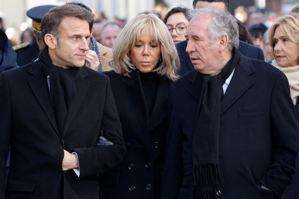 Francúzsky prezident Emmanuel Macron a jeho manželka Brigitte Macronová a francúzsky premiér Francois Bayrou kráčajú neďaleko miesta útoku na Charlie Hebdo. FOTO: Reuters