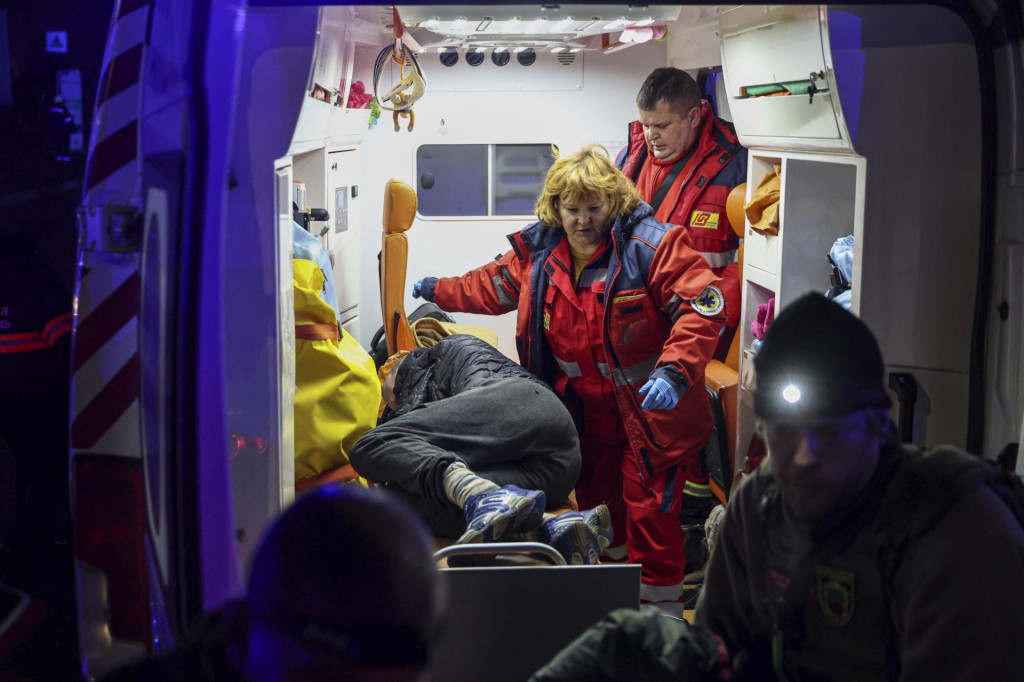 Záchranári poskytujú prvú pomoc zranenej osobe po útoku ruskej armády na ukrajinské mesto Záporožie. FOTO: TASR/AP