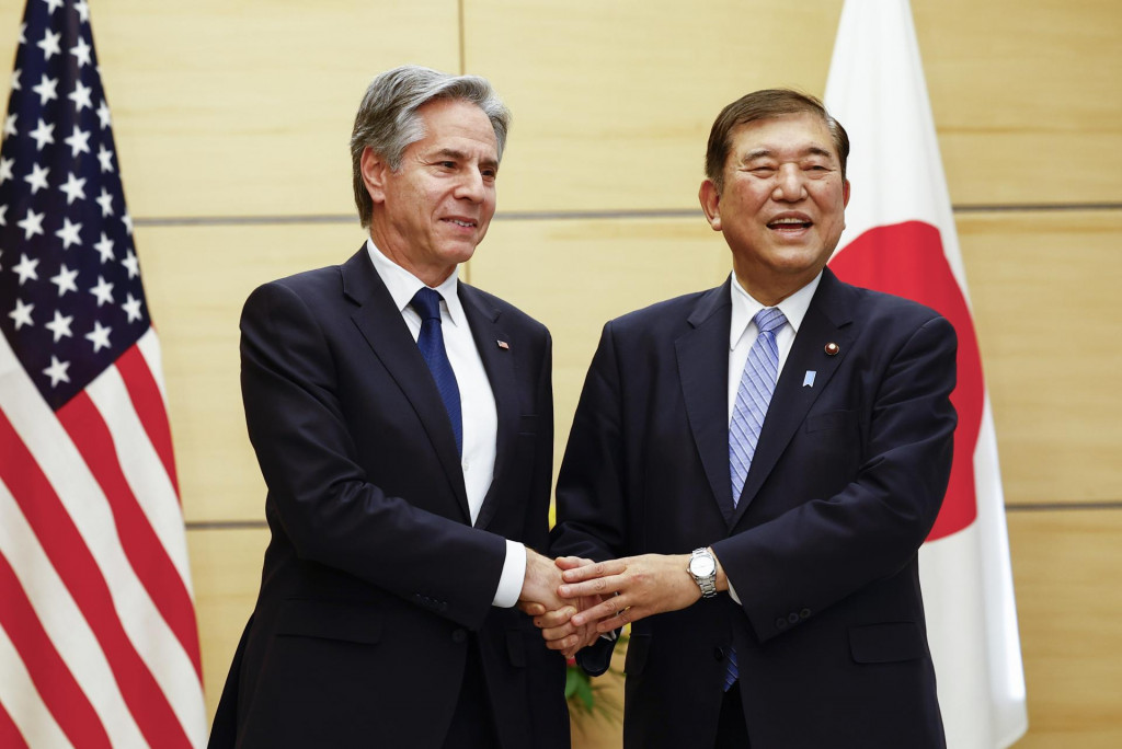 Americký minister zahraničných vecí Antony Blinken (vľavo) a japonský premiér Šigeru Išiba si podávajú ruky počas stretnutia v Tokiu. FOTO: TASR/AP