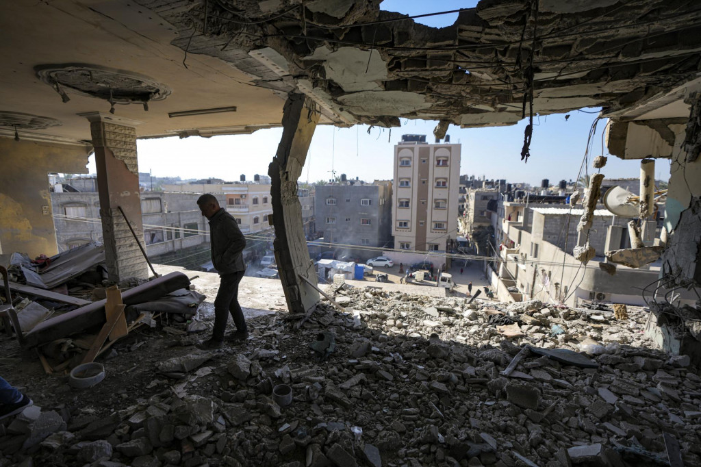 Palestínčan sa pozerá na poškodenú obytnú budovu po nočnom izraelskom útoku v meste Dajr al-Balah v Pásme Gazy. FOTO: TASR/AP