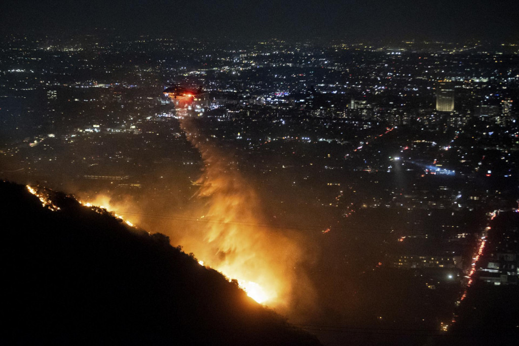 Vrtuľník zhadzuje vodu počas lesného požiaru v štvrti Hollywood Hills v meste Los Angeles americkom štáte Kalifornia. FOTO: TASR/AP