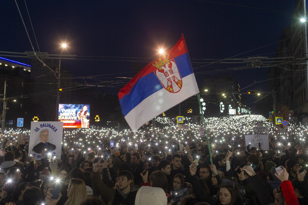 Demonštranti svietia mobilnými telefónmi počas protestu proti srbskému prezidentovi Aleksandarovi Vučičovi a jeho vláde v Belehrade. FOTO: TASR/AP