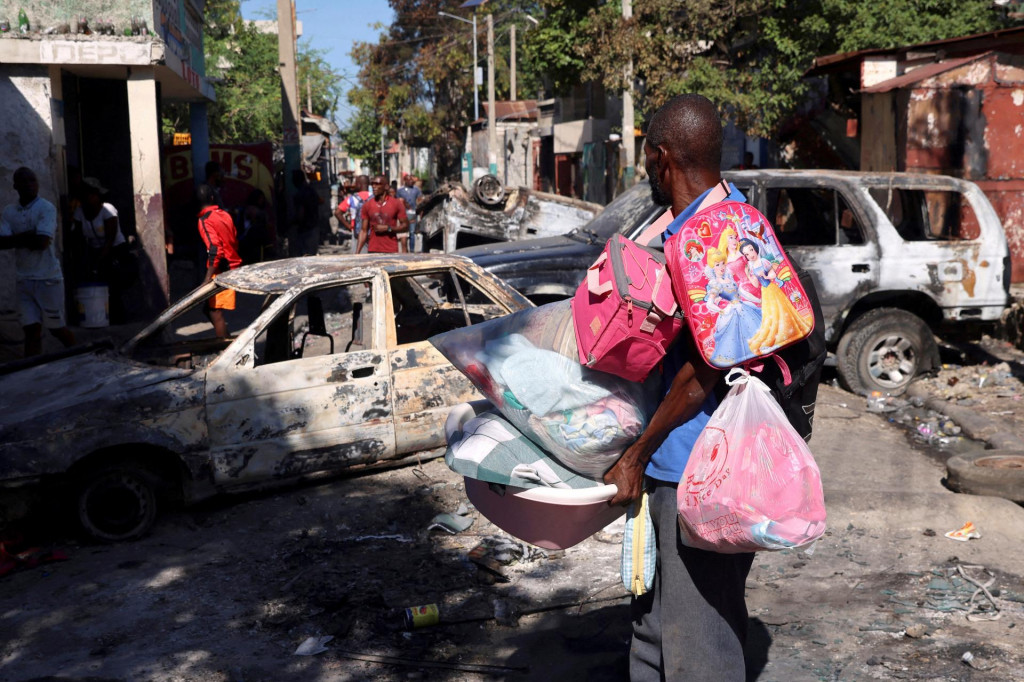 Muž nesúci svoje veci pri úteku z predmestia Poste Marchand v Port-au-Prince na Haiti. FOTO: Reuters