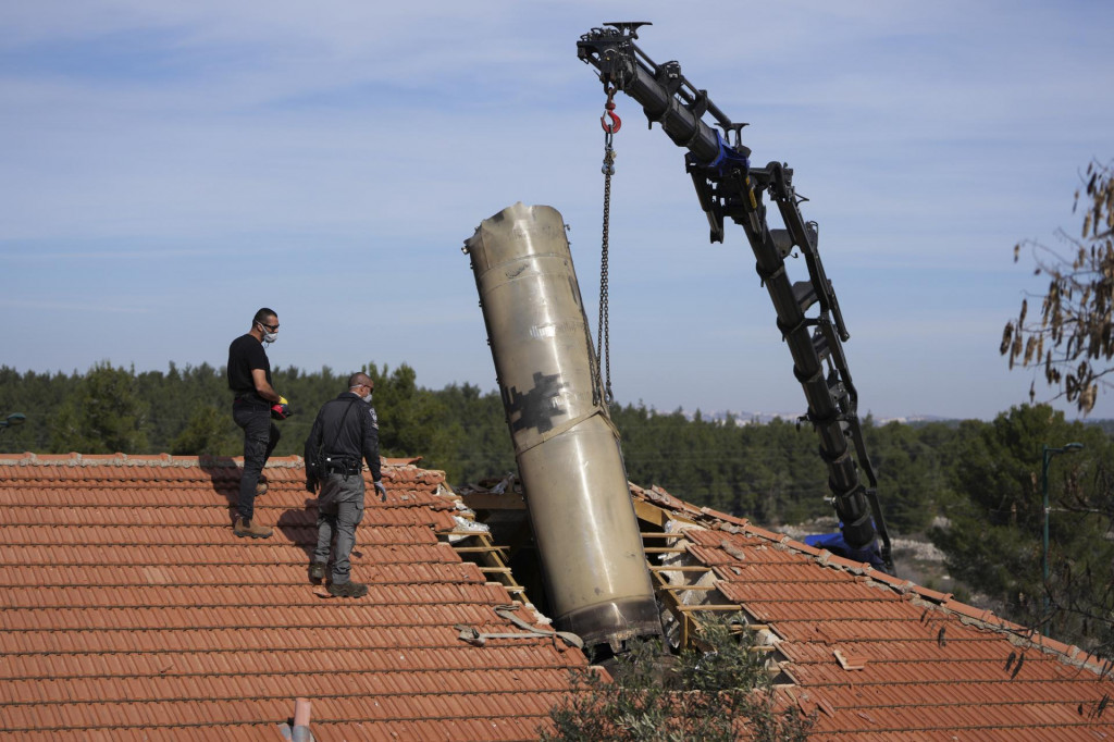 Izraelskí pyrotechnici odstraňujú časť rakety, ktorú húsíovia vypálili z Jemenu zo strechy rodinného domu v izraelskej dedine Mevo Bejtar neďaleko Jeruzalema. FOTO: TASR/AP