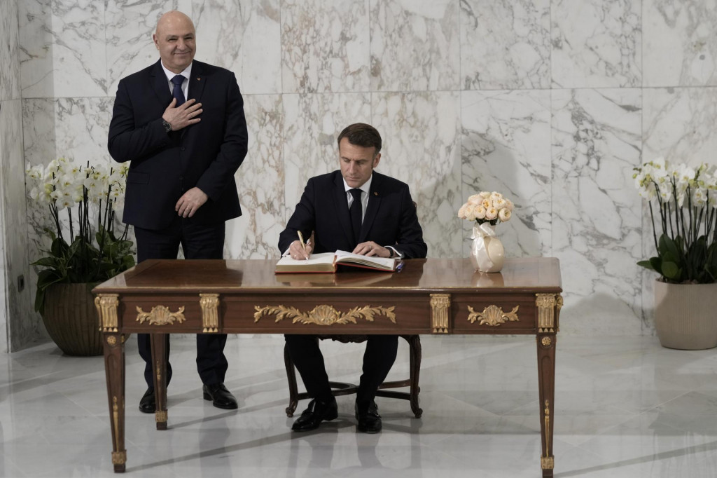 Francúzsky prezident Emmanuel Macron (vpravo) sa zapisuje do knihy hostí vedľa nového libanonského prezidenta Džúzífa Awna počas ich stretnutia v prezidentskom paláci v meste Bábda. FOTO: TASR/AP