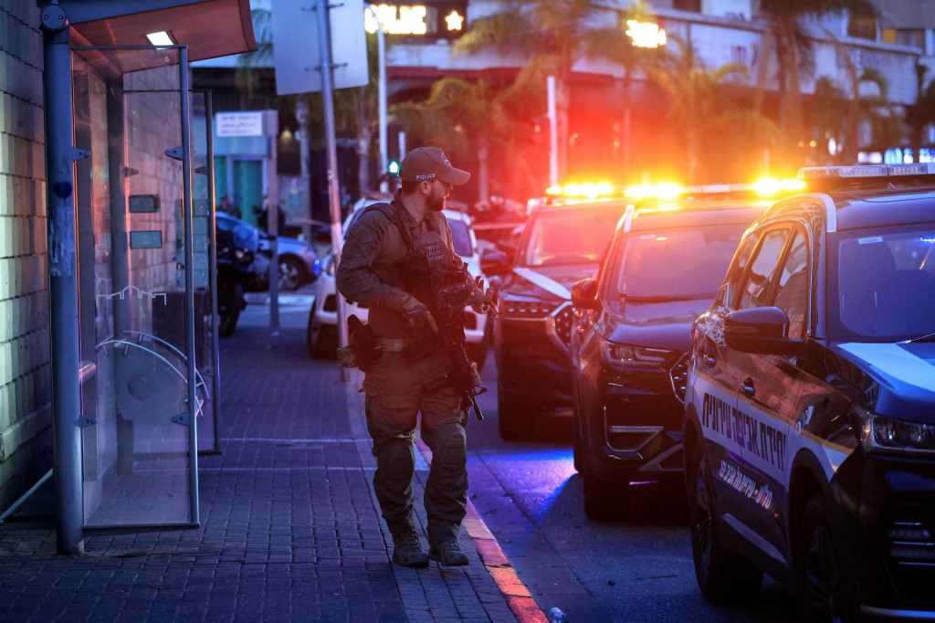 Izraelský policajt kráča na mieste údajného útoku v Tel Avive. FOTO: Reuters