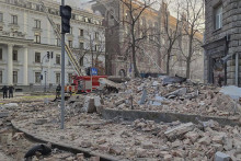 Trosky ležia na ulici z neďalekých zničených budov po ruskom dronovom útoku. FOTO: TASR/AP