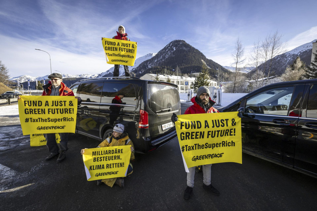 Aktivisti Greenpeace blokujú cestu k heliportu počas protestu pred začiatkom 55. Svetového ekonomického fóra vo švajčiarskom Davose. FOTO: TASR/AP