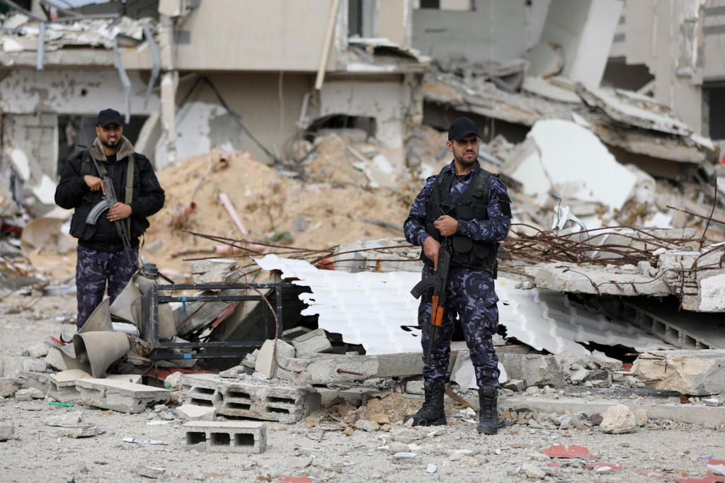 Palestínski policajti Hamasu strážia svoje zničené veliteľstvo po prímerí medzi Izraelom a Hamasom v Gaze. FOTO: Reuters