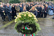 Ľudia v tichosti stoja pred vencom deň po tom, čo dvaja ľudia zahynuli pri útoku nožom v nemeckom Aschaffenburgu.. FOTO: Reuters