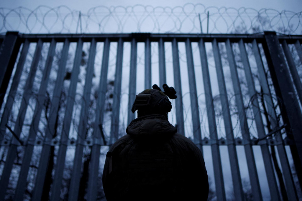 Poľský vojak stojí na stráži pred bariérou na poľsko-bieloruskej hranici. FOTO: Reuters
