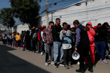 Predstaviteľ Komisie pre pomoc utečencom sa rozpráva s migrantmi mimo Mexickej komisie pre pomoc utečencom, ktorí čakajú v rade na legalizáciu svojej migračnej situácie v krajine. FOTO: Reuters