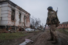 Ukrajinský vojak stojí na ceste v prvej línii v Charkovskej oblasti. FOTO: Reuters
