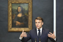 Francúzsky prezident Emmanuel Macron gestikuluje pred obrazom Mony Lisy od Leonarda da Vinciho počas tlačovej konferencie v múzeu Louvre v Paríži. FOTO: TASR/AP