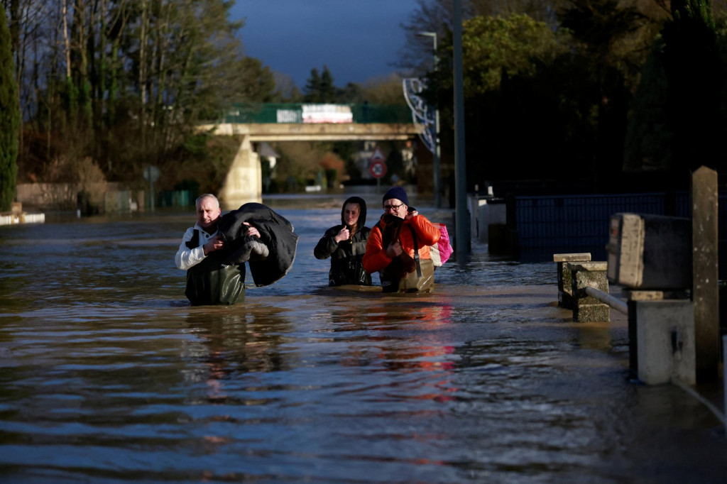 Obyvatelia kráčajú po zaplavenej ulici v Guipry-Messac  v západnom Francúzsku. FOTO: Reuters
