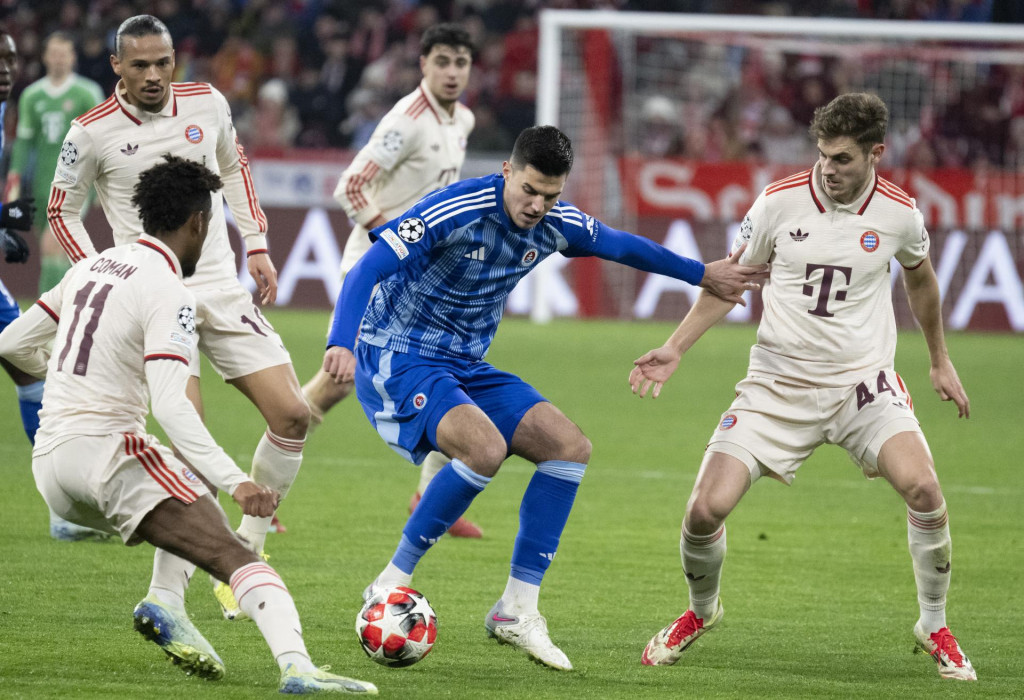 Uprostred Marko Tolič (Slovan), vľavo Kingsley Coman, v pozadí vľavo Leroy Sané a Josip Stanišič (všetci Bayern) bojujú o loptu počas zápasu záverečného 8. kola ligovej fázy Ligy majstrov vo futbale Bayern Mníchov - Slovan Bratislava v Mníchove. FOTO: TASR/Martin Baumann