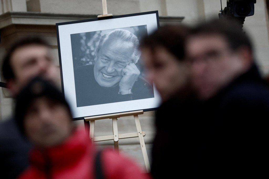 Ľudia prechádzajú okolo fotografie niekdajšieho vodcu francúzskej krajnej pravice Jeana-Marie Le Pena. FOTO: Reuters