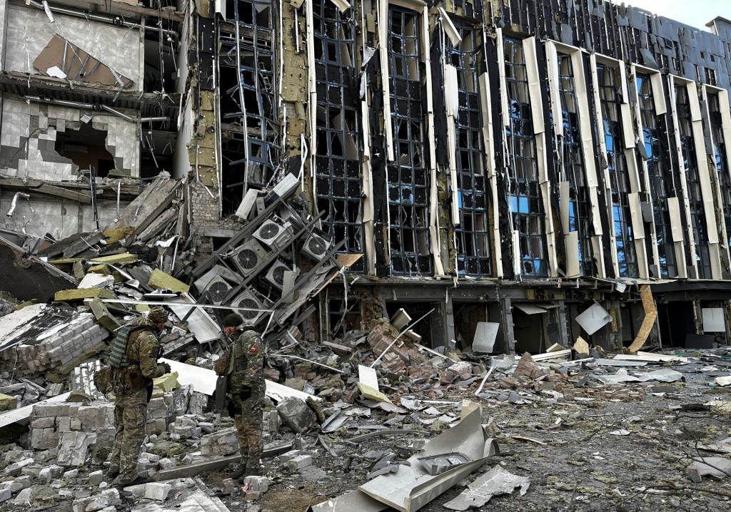 Členovia policajného bombového komanda pracujú na mieste budovy zasiahnutej ruským raketovým útokom v meste Izium. FOTO: Reuters
