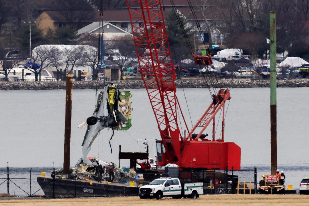 Čln nesúci žeriav presúva časti vraku z rieky Potomac. FOTO: Reuters