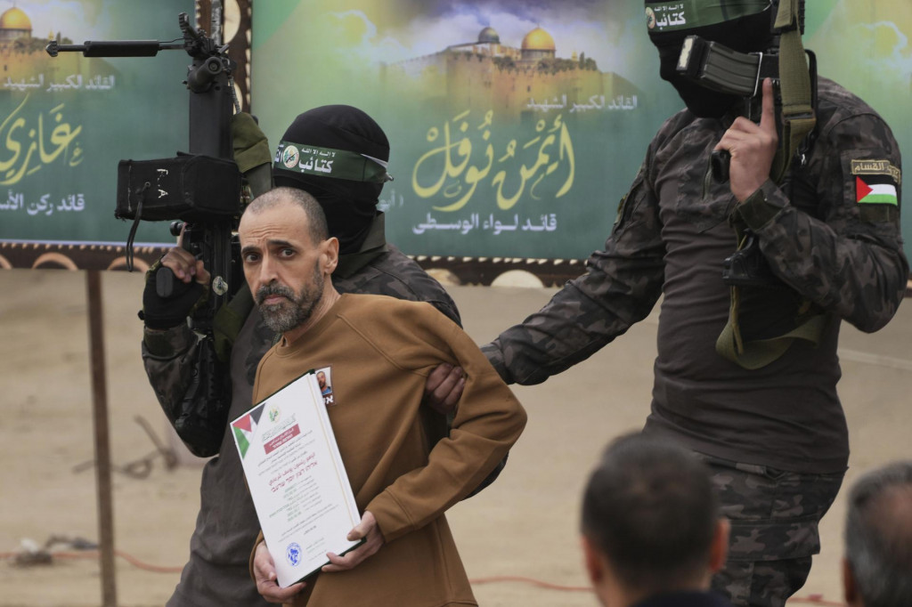 Unesený izraelský rukojemník Elih Šarabi, ktorý bol v zajatí od útoku palestínskeho militantného hnutia Hamas na juh Izraela zo 7. októbra 2023, pózujú s bojovníkmi Hamasu pred svojím odovzdaním Červenému krížu v meste Dajr al-Balah v Pásme Gazy. FOTO: TASR/AP