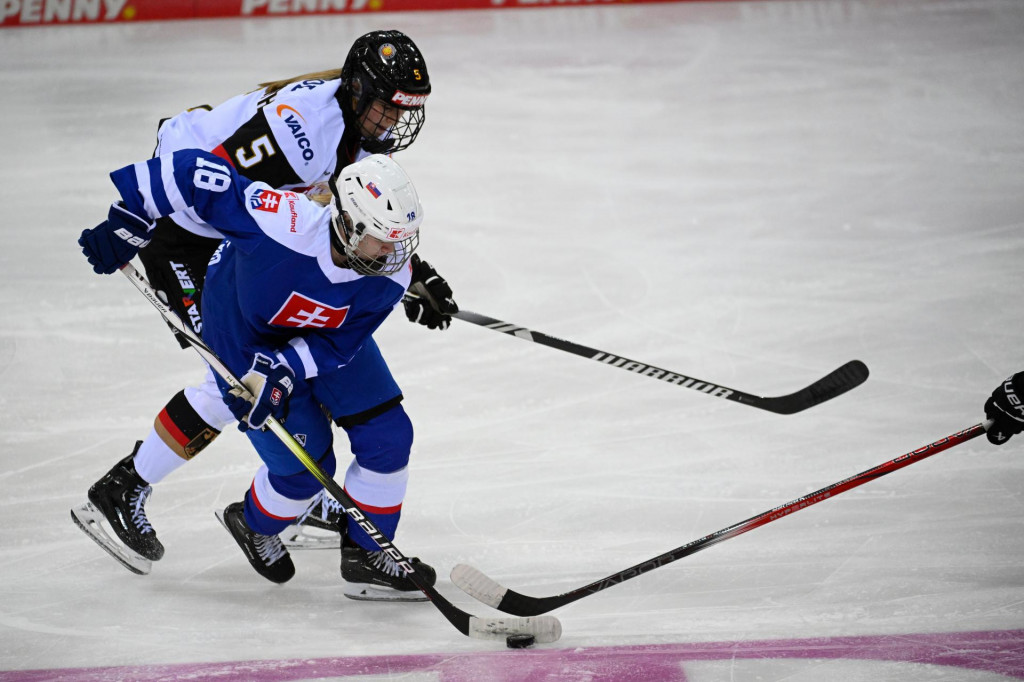 Slovenská hokejistka Ema Tóthová (uprostred) a hráčka Nemecka Charlotte Schaffrathová bojujú o puk v zápase I. skupiny finálového turnaja kvalifikácie ZOH 2026 Slovensko - Nemecko v Bremerhavene. FOTO: TASR/DPA