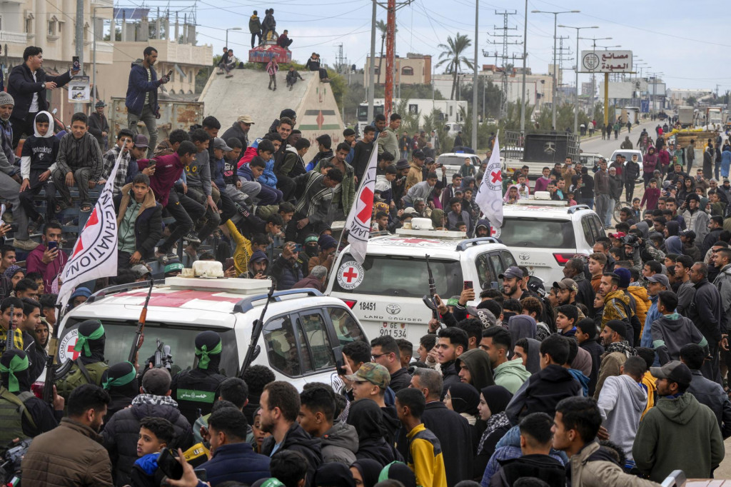 Vozidlá Červeného kríža, ktoré sprevádzajú bojovníci palestínskeho radikálneho hnutia Hamas, odvážajú prepustených izraelských rukojemníkov v meste Dajr al-Balah v Pásme Gazy. FOTO: TASR/AP