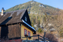 Na snímke v popredí drevený zrubový domček a v pozadí vrch Sidorovo v podhorskej osade Vlkolínec, ktorá je miestnou časťou okresného mesta Ružomberok. Vlkolínec je od roku 1993 zapísaný do zoznamu svetového kultúrneho a prírodného dedičstva UNESCO. FOTO: TASR/Daniel Stehlík