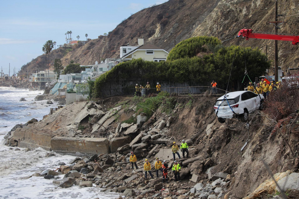 Hasiči vyslobodili auto, ktoré bolo počas zosuvu bahna zmietnuté do oceánu v Malibu. FOTO: Reuters