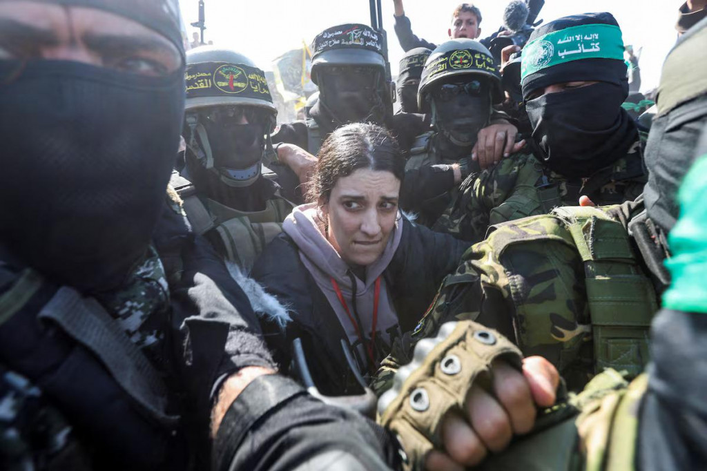 Palestínski militanti obkľúčia rukojemníčku Arbel Jehoudovú v deň, keď ju odovzdajú členom Medzinárodného výboru Červeného kríža v rámci prímeria a výmeny väzňov medzi Hamasom a Izraelom v južnom pásme Gazy. FOTO: Reuters