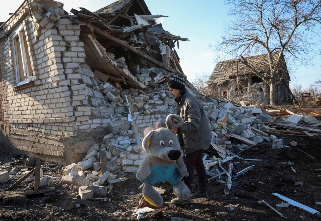 Obyvateľka Natalia zbiera hračky svojej vnučky, ktoré boli rozhádzané po zasiahnutí ich domu ruským leteckým útokom. FOTO: Reuters