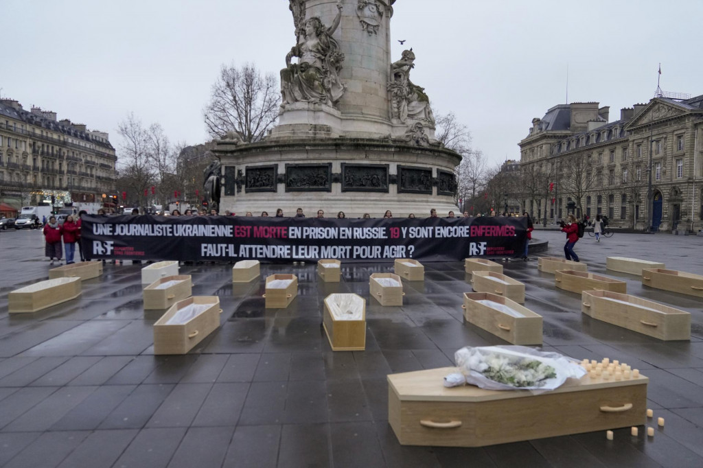 Členovia organizácie Reportéri bez hraníc kladú makety rakví počas protestu proti väzneniu ukrajinských novinárov v Rusku na Námestí republiky v Paríži. FOTO: TASR/AP