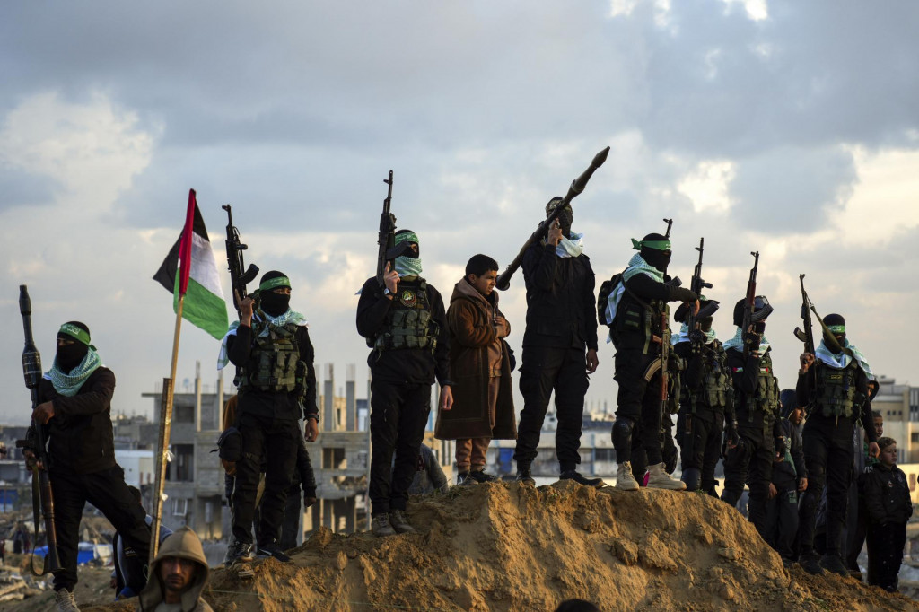 Príslušníci palestínskeho militantného hnutia Hamas stoja na svojich pozíciách pred odovzdaním tiel štyroch zosnulých izraelských rukojemníkov v meste Chán Júnis na juhu Pásma Gazy. FOTO: TASR/AP