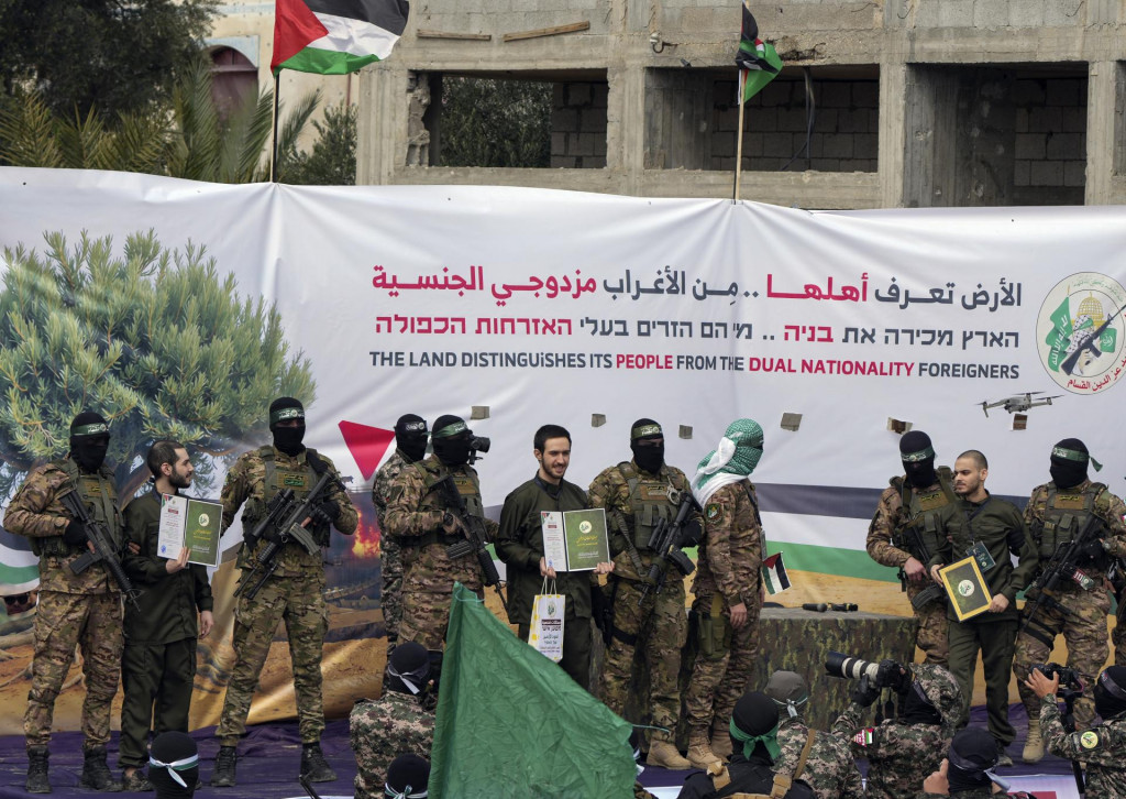 Izraelskí rukojemníci Elija Cohen (vľavo), Omer Šem Tov (uprostred) a Omer Wenkert v sprievode maskovaných bojovníkov Hamasu pred odovzdávaním pracovníkom Červeného kríža v Nusajráte v sobotu 22. februára 2025. FOTO: TASR/AP