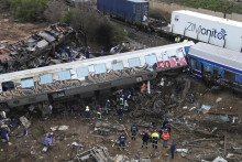 Hasiči a záchranári zasahujú na mieste zrážky nákladného a osobného vlaku v blízkosti mesta Larisa na severe Grécka. FOTO: TASR/AP
