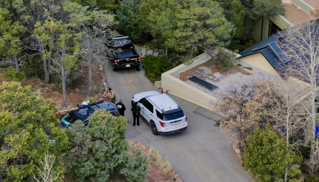 Policajti pred domom amerického oscarového herca Genea Hackmana, v ktorom našli herca mŕtveho spolu s manželkou a ich psom v americkom Santa Fe v štáte Nové Mexiko. FOTO: TASR/AP
