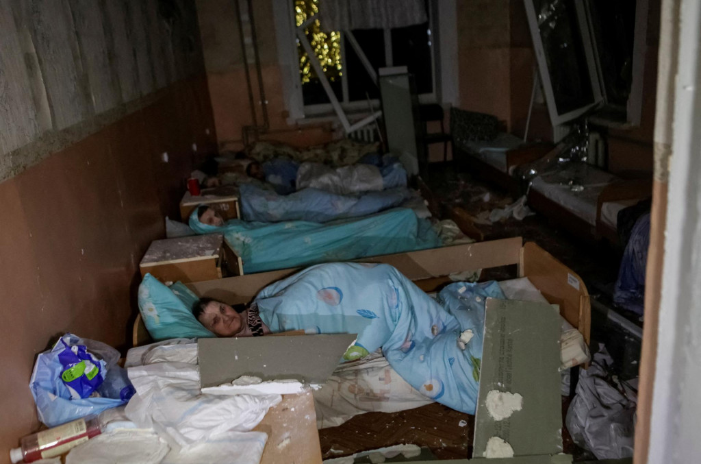Pacienti ležia na lôžkach na poškodenom oddelení a čakajú na evakuáciu z nemocnice zasiahnutej ruským dronovým útokom v Charkove. FOTO: Reuters