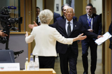 Predsedníčka Európskej komisie Ursula von der Leyenová (chrbtom) a predseda Európskej rady António Costa sa vítajú počas príchodu na mimoriadny summit lídrov členských krajín EÚ v Bruseli. FOTO: TASR/AP